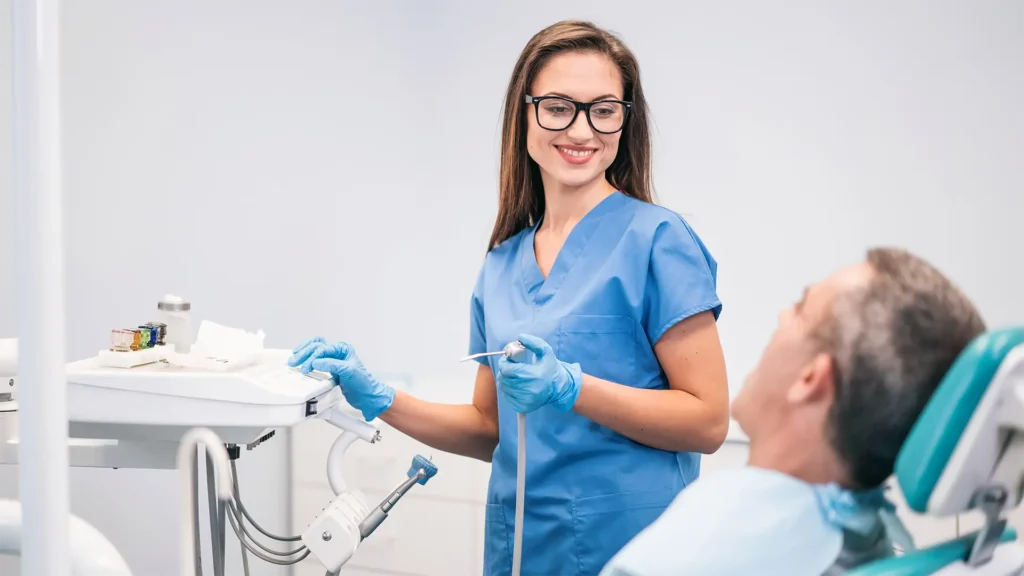 dental assistant helping old patient