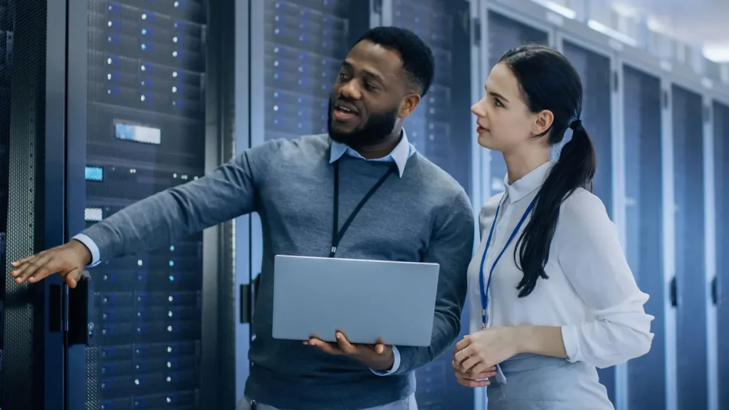 black male and white female IT professionals in a server room