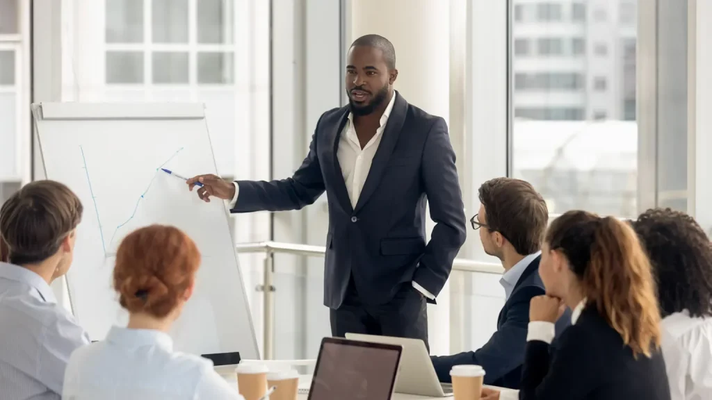 black male presenting to a group in office environment