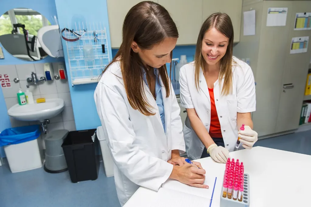 two healthcare workers looking at blood samples