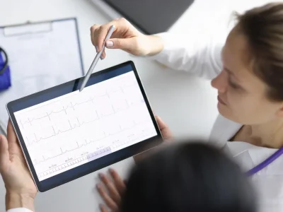 EKG-technician-using-tablet-reviewing-data-with-doctor